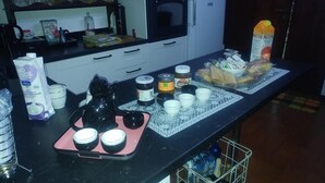 A kitchen counter with various food items and containers, a microwave, and a coffee machine. - B&B Il Cedro (Foligno)