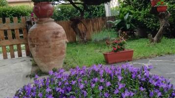 Un jardín con una maceta grande y un parterre floral.