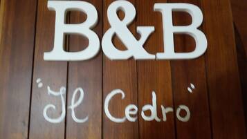 Wooden letters spelling "B&B" and "El Cedro" on a wooden surface.