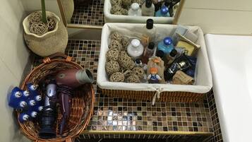 A bathroom with a tiled floor, a wicker basket, and a wicker basket with a plant.