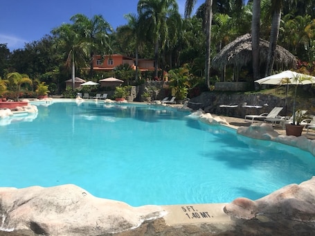 Una piscina al aire libre, sombrillas