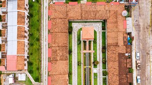 Luchtbeeld van een woonwijk met een centraal gelegen binnenplaats, omringd door huizen met rode dakpannen.