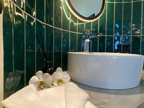 A bathroom with a white sink, a mirror, and green tiled walls. - Hotel Ojo de Agua (Ciudad Hidalgo)