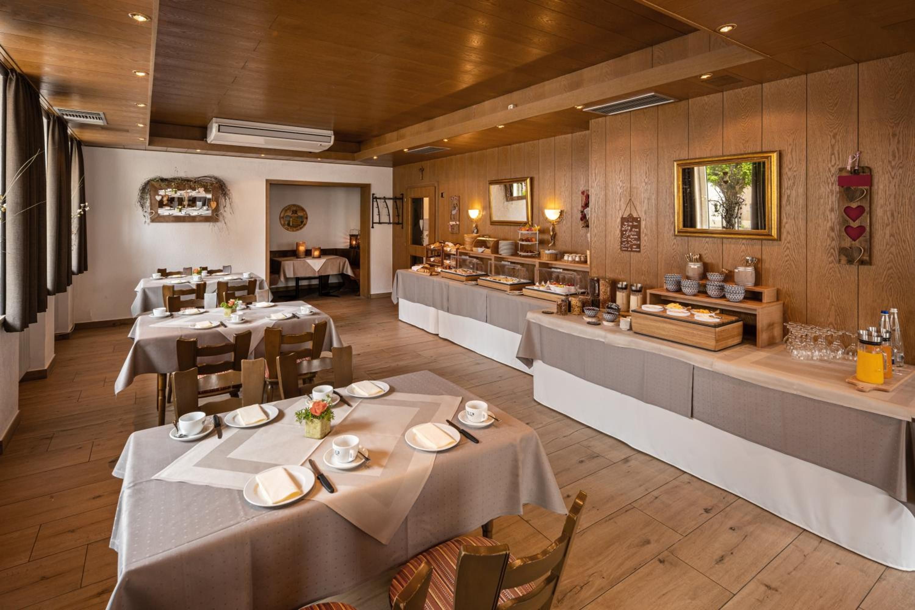 Ein Restaurant mit mehreren Tischen, einer Speiseauslage und einer Holzvertäfelung.