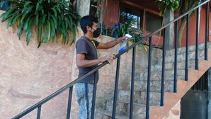Une personne nettoie un escalier à l’aide d’un vaporisateur et d’un chiffon.