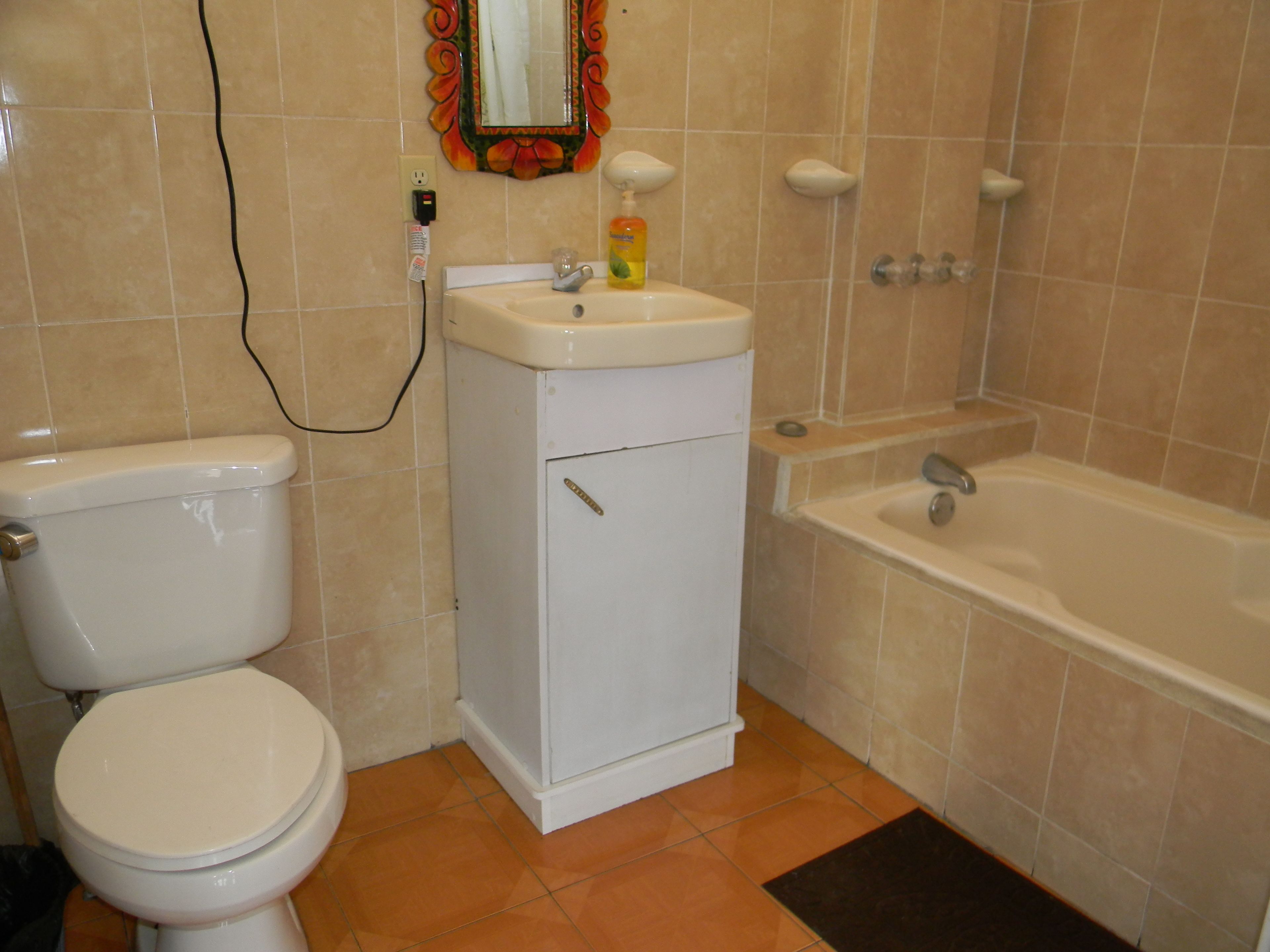 A bathroom with a toilet, sink, and bathtub.