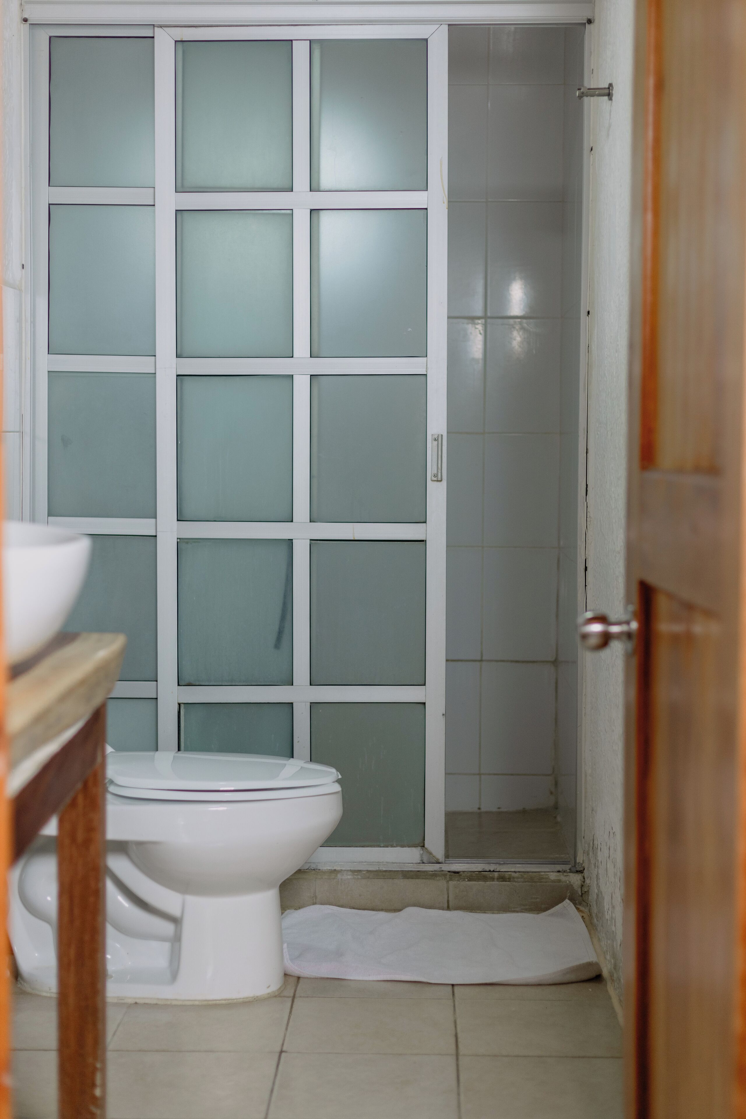 Une salle de bain comprenant des toilettes, un lavabo et un espace douche.