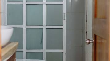 Une salle de bain comprenant des toilettes, un lavabo et un espace douche.
