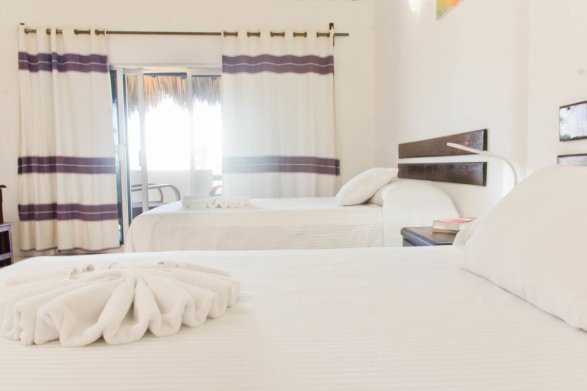 Habitación doble estándar, 2 camas matrimoniales, vista a la alberca | Minibar, tabla de planchar con plancha y ropa de cama