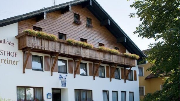 A traditional wooden building with a sign for "Landhotel GASTHOF Schreinser."