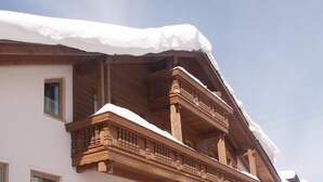 A building with a snow-covered roof and wooden balcony railings.