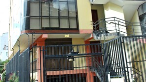 Un edificio de varios pisos con fachada de vidrio, entrada porticada y una escalera que conduce a los pisos superiores.