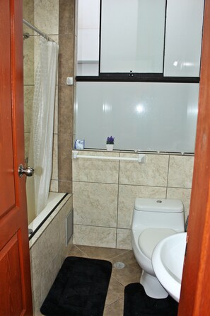 A bathroom with a toilet, a shower, and a sink. - Comfortable Departamento Familiar Cusco (Cusco)