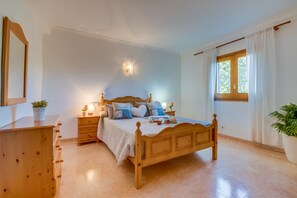 A bedroom with a wooden bed, bedside tables, a dresser, a mirror, and a window with curtains. - Country style Finca Can Verga Pollensa with pool (Pollensa)