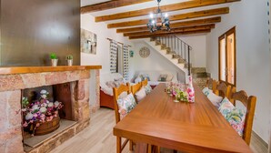 A dining area with a wooden table, chairs, a fireplace, and a staircase. - Country style Finca Can Verga Pollensa with pool (Pollensa)