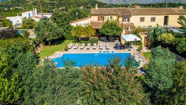 A villa with a swimming pool, surrounded by lush greenery and mountains in the background. - Country style Finca Can Verga Pollensa with pool (Pollensa)