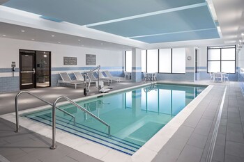 A modern hotel lobby with a bar, seating area, and artwork on the walls. at Hyatt Place Mount Pleasant Towne Centre