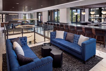 An indoor swimming pool with clear water, metal railings, and lounge chairs. at Hyatt Place Mount Pleasant Towne Centre