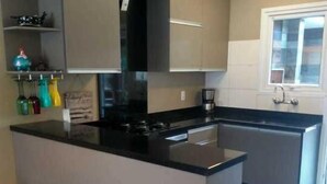 A modern kitchen with a central island, built-in appliances, and a window.
