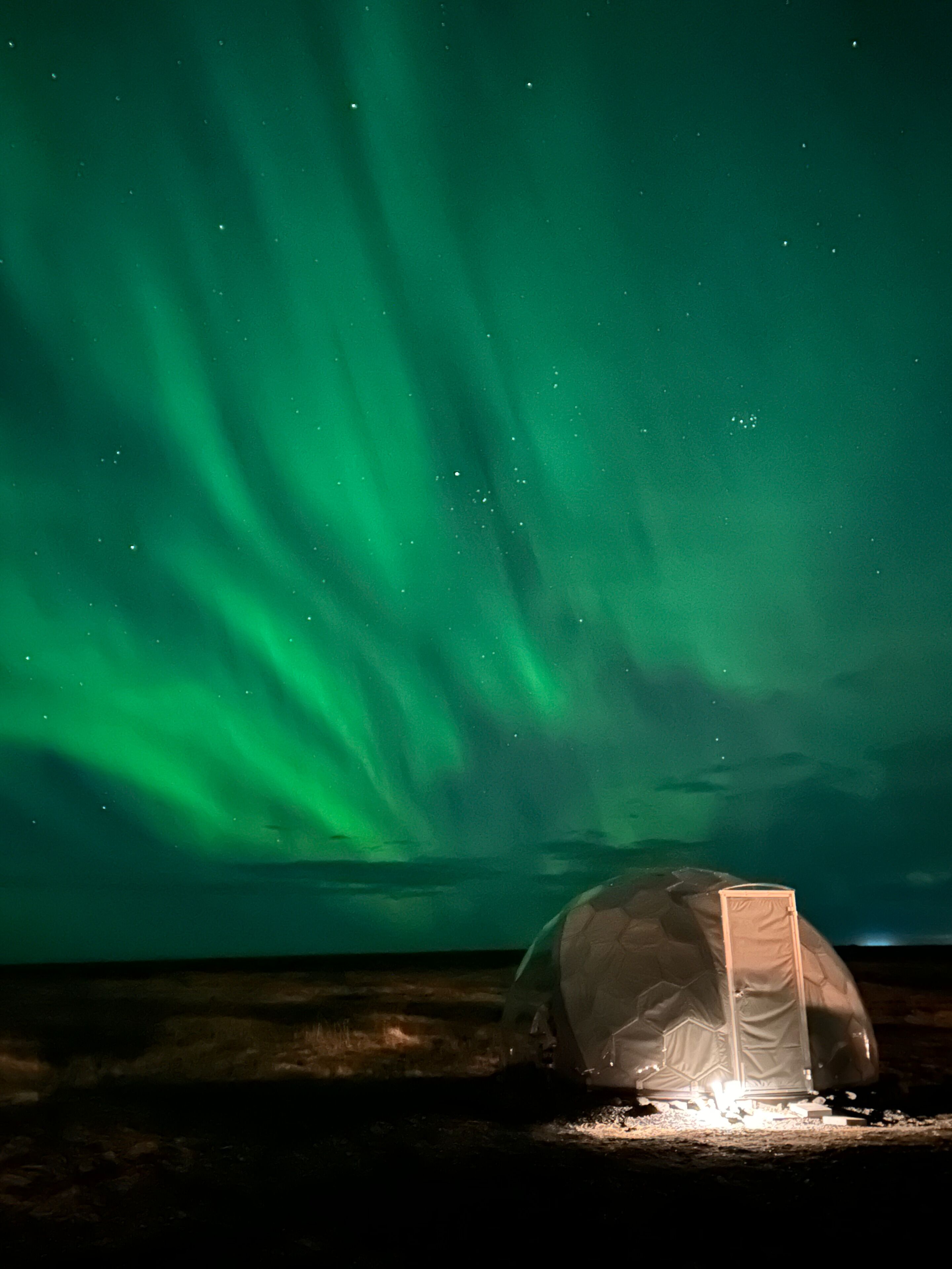 Ein Zelt unter einem Nachthimmel mit Polarlichtern.