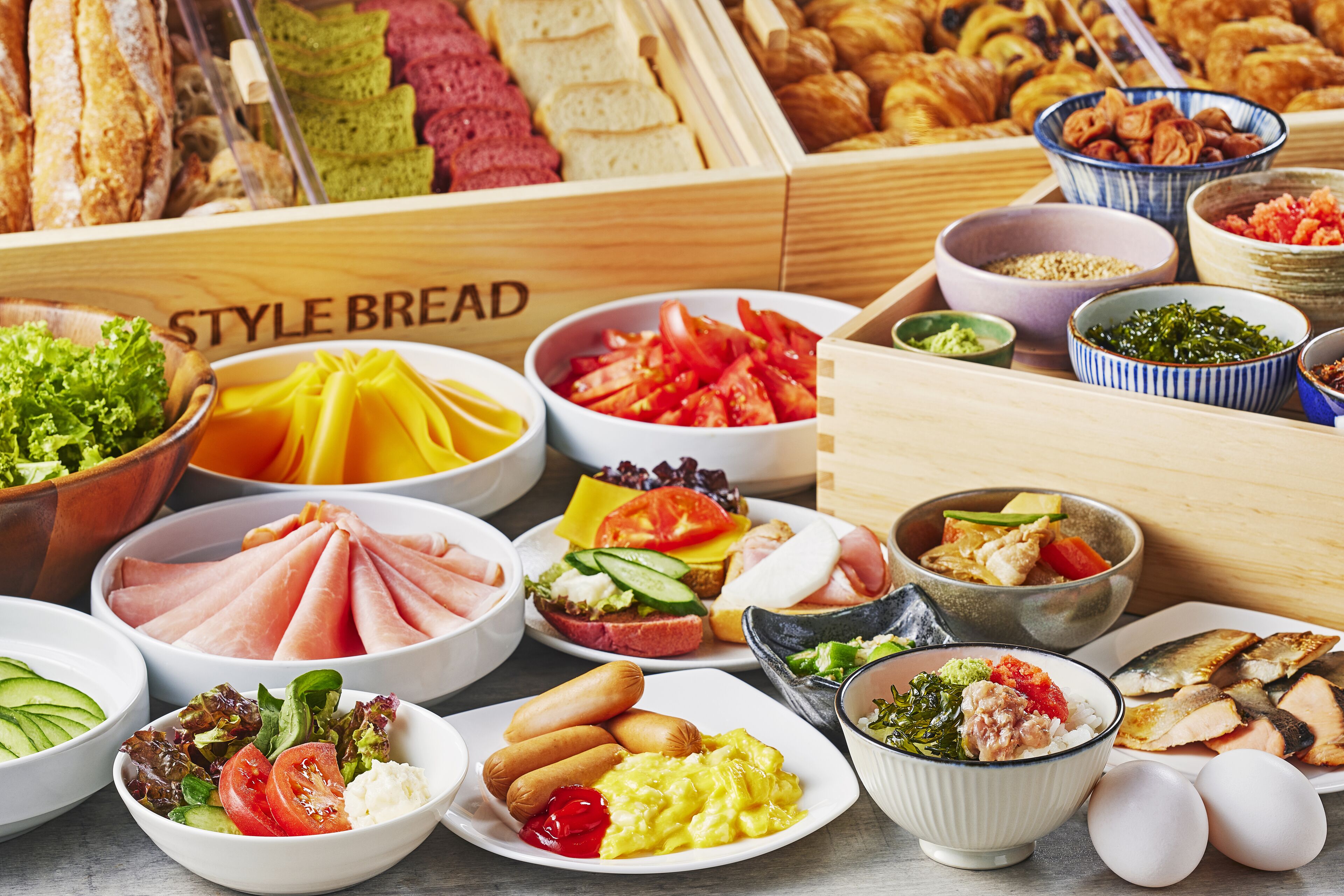 Un assortiment de produits pour le petit-déjeuner, notamment du pain, des œufs et des légumes.
