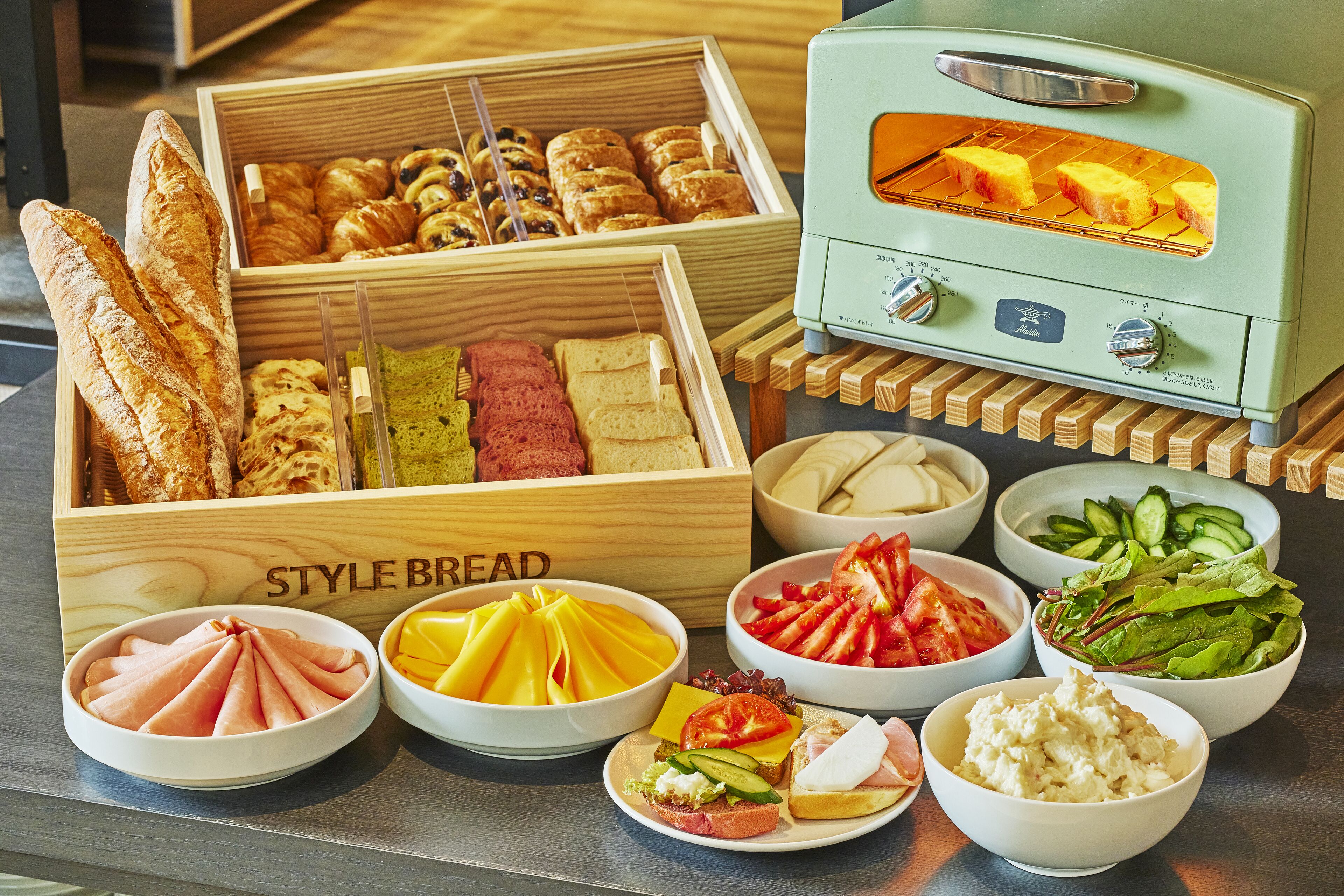 A variety of food items including bread, pastries, and salads displayed on a table.