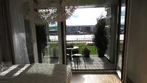 Un dormitorio con un ventanal grande, una cama y vistas a un balcón con mobiliario exterior.