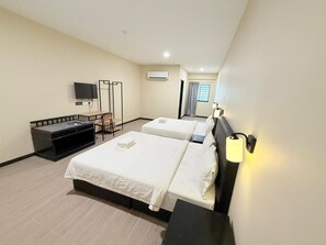 A hotel room with two beds, a desk with a chair, a TV, and a window with curtains. - Pertama Lodge (Tawau)