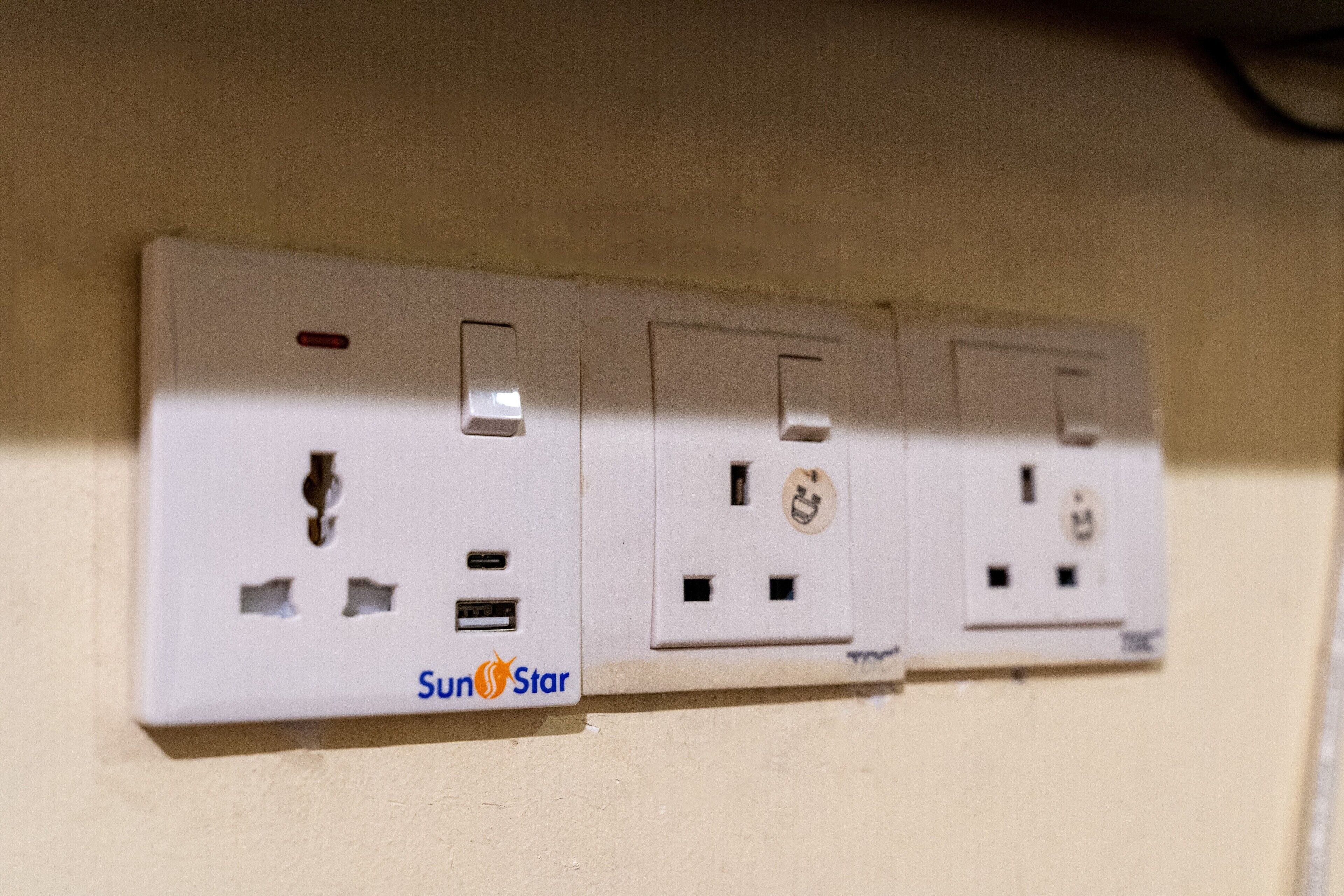 Een wandcontactdoos met het merknaam "SunStar" zichtbaar.