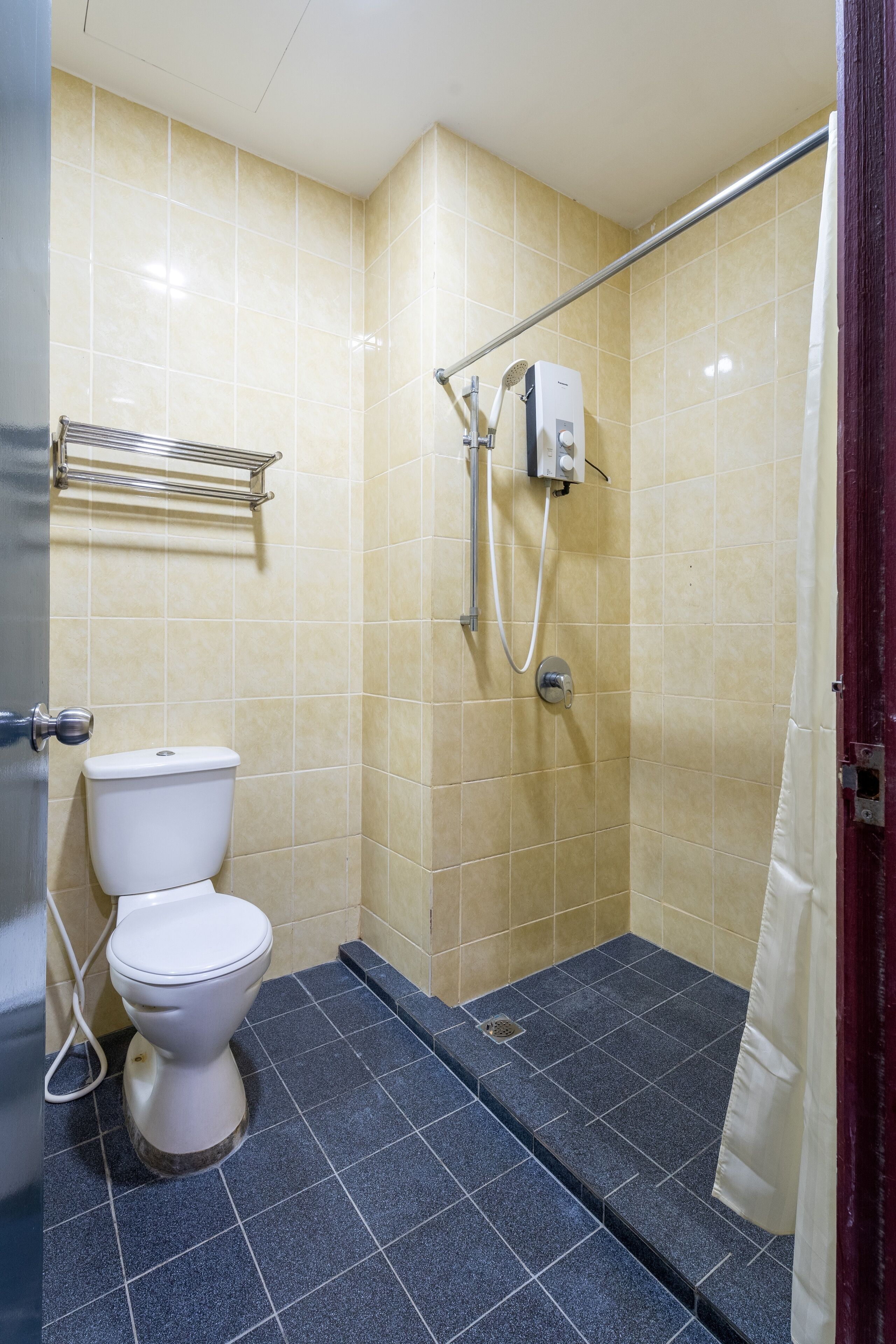 Ein Badezimmer mit Toilette, Dusche und gefliesten Wänden.