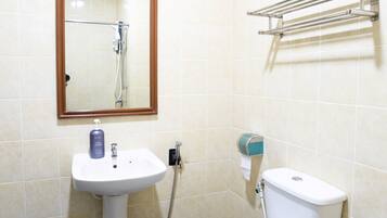 A bathroom with a white sink, a toilet, a mirror, and a towel rack.