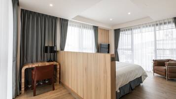 Una habitación de hotel moderna con un escritorio de madera, una cama y un sofá.