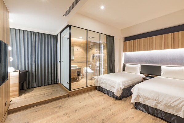 Een moderne hotelkamer met twee bedden, een bureau, een douche en een grote spiegel.
