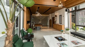 Un interior moderno con zona de comedor, una planta grande y vistas al exterior.