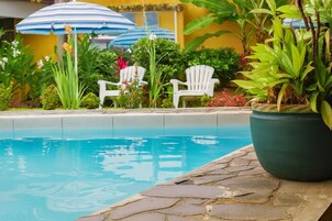 Una piscina al aire libre, sillones reclinables de piscina