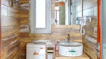 A compact bathroom with a toilet, sink, and wooden wall paneling.