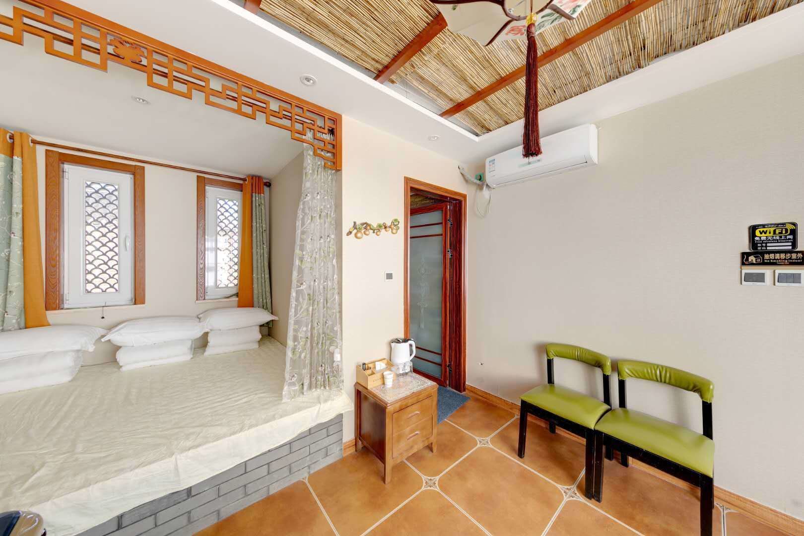 Un dormitorio con cama, una mesita con hervidor y una silla.
