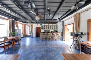 Una habitación amplia con cocina, una mesa de comedor y sillas, y una barra con taburetes.