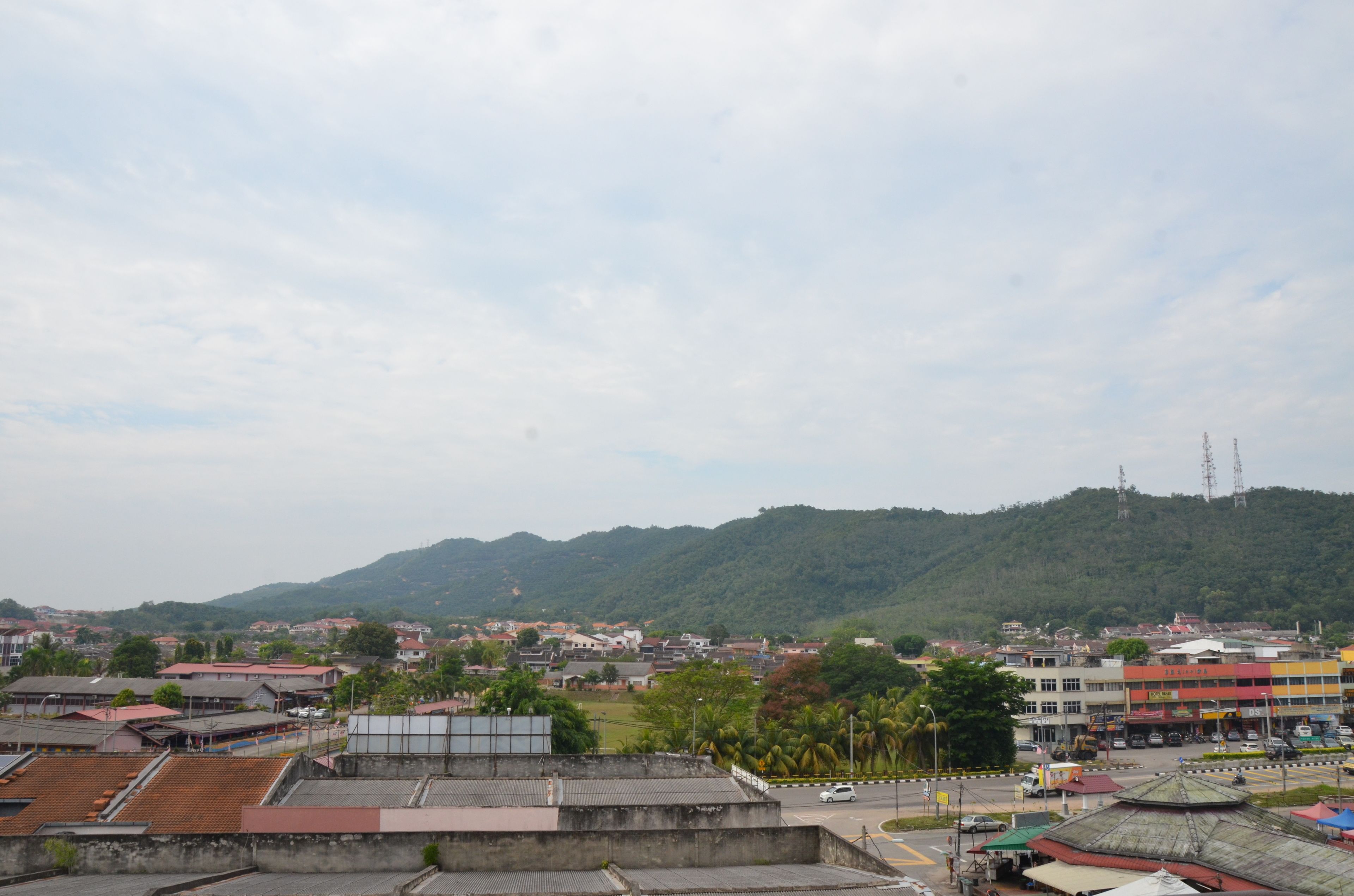 A town with buildings, a road, and a hill in the background.
