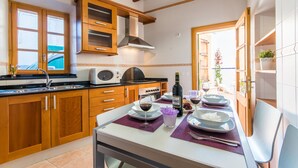 Une cuisine moderne avec des meubles en bois, un four à micro-ondes encastré et un coin repas aménagé pour prendre un repas.