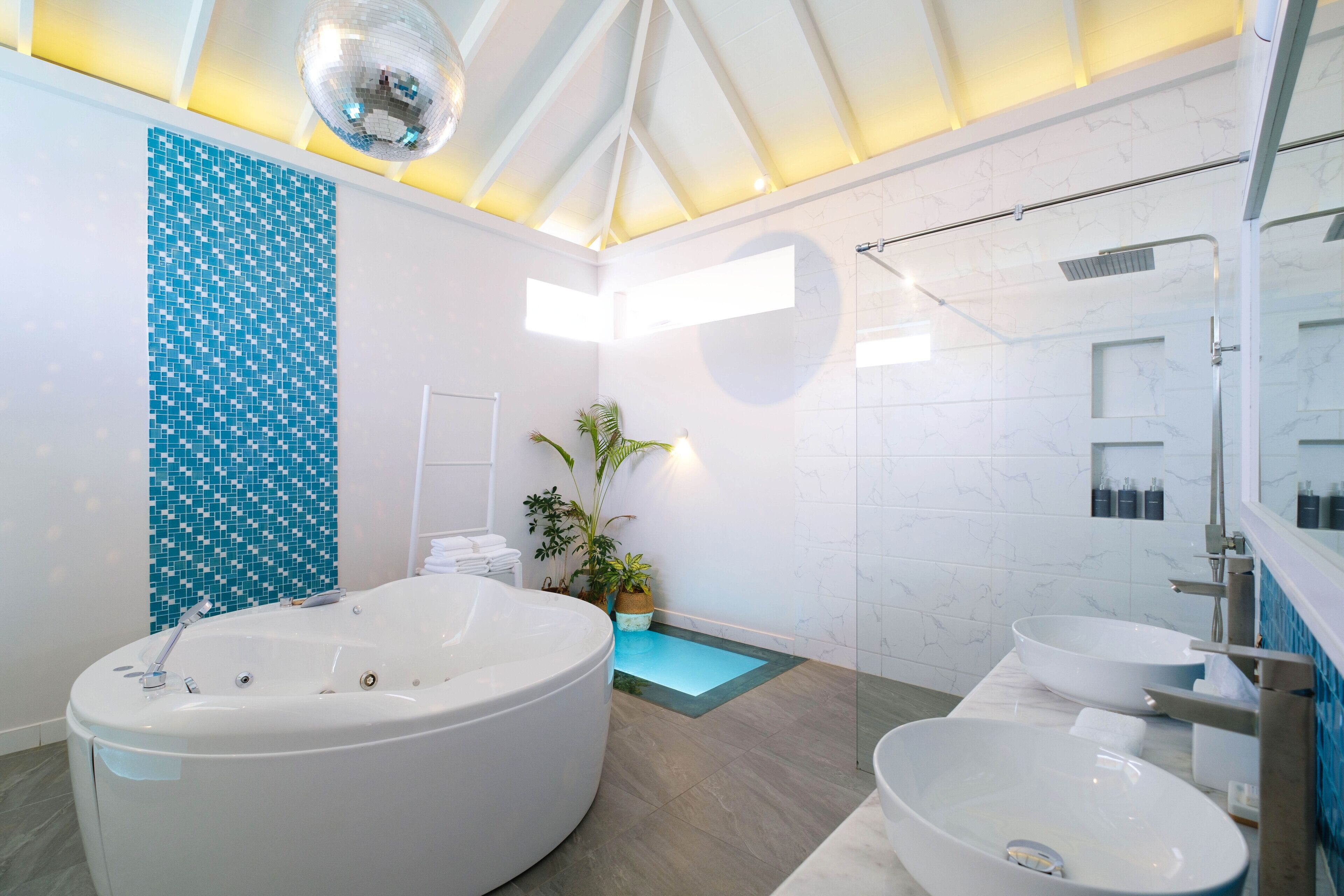 A modern bathroom with a freestanding bathtub, a glass-enclosed shower, and a large mirror.
