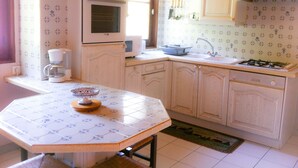 A kitchen with a stove, oven, and coffee maker.