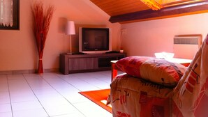 A living room with a television, a lamp, and a decorative vase.