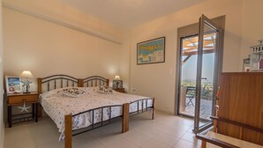 Una camera da letto con un letto, due comodini, una mappa appesa al muro e una porta scorrevole in vetro che dà su uno spazio all'aperto.