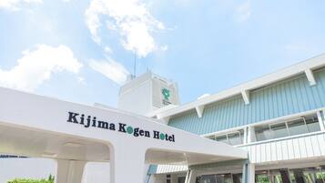 The exterior of the Kijima Kogen Hotel with a clear sky and a modern building structure.