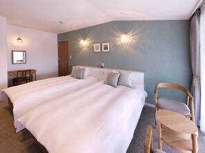 Ein Hotelzimmer mit einem großen Bett, einem Schreibtisch und zwei Wandleuchten.