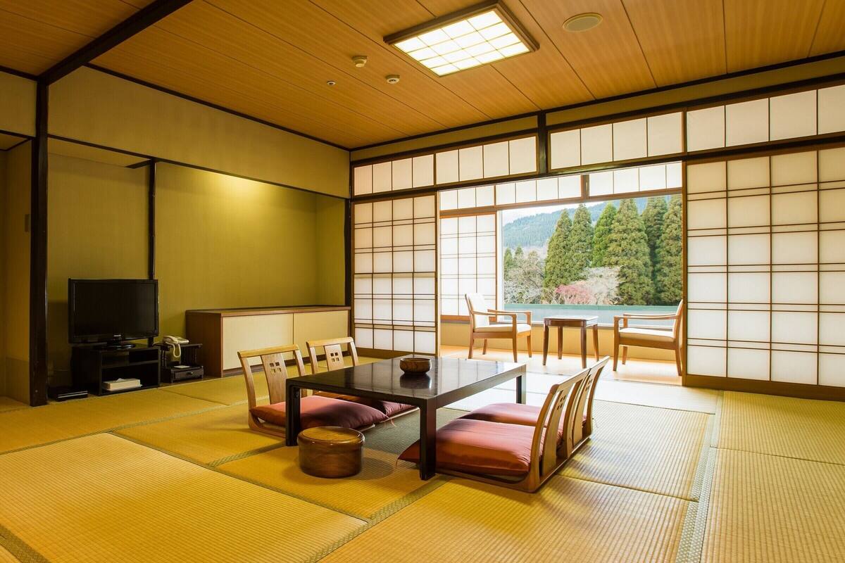 A traditional Japanese room with tatami flooring, a low table, and sliding doors.