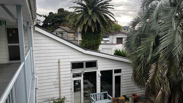 Il s’agit d’une propriété résidentielle dotée d’un petit patio, d’une porte-fenêtre coulissante, d’un banc blanc et d’un palmier.