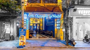 A hostel with a bright yellow facade, multiple windows, and a sign reading "Little Charm Hostel." - Little Charm Hanoi Hostel (Hanoi)
