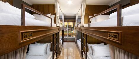 A hotel room with bunk beds, each bed labeled with a number.